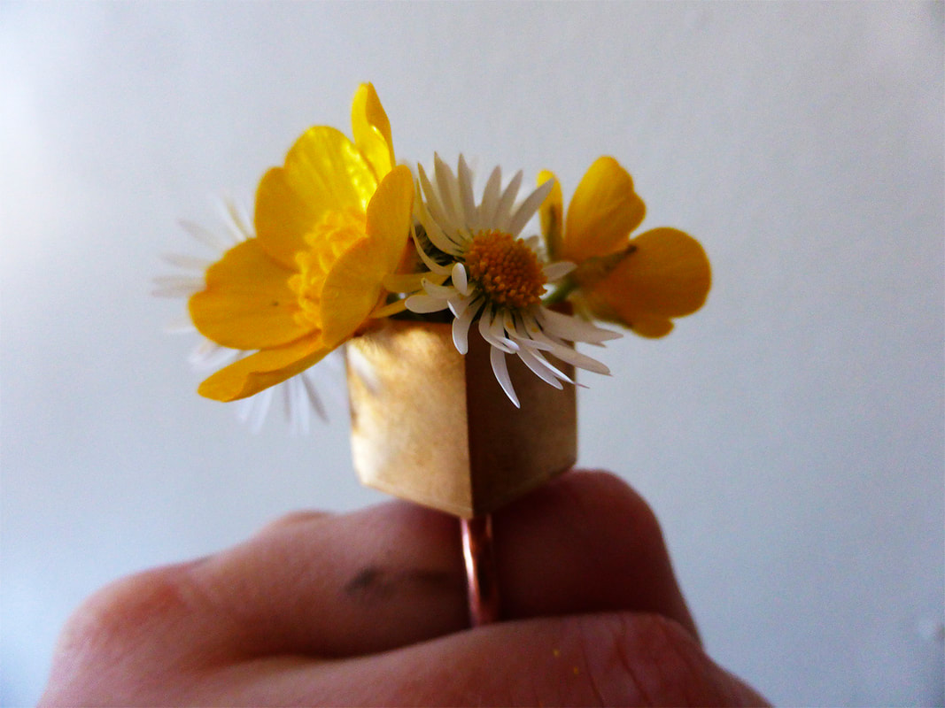 square copper ring with daisy and buttercups on finger  