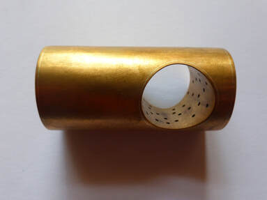 cylindrical copper ring with ole on pale background