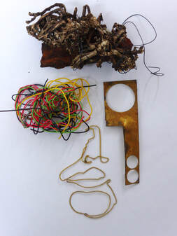 dried seaweed copper and brass pieces and wire laid flat to resemble a face