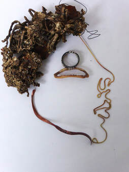copper and brass wire, petrified seaweed, bone piece laid flat to resemble a face