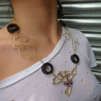 model with white t shirt wearing brass, rubber and garnet necklace