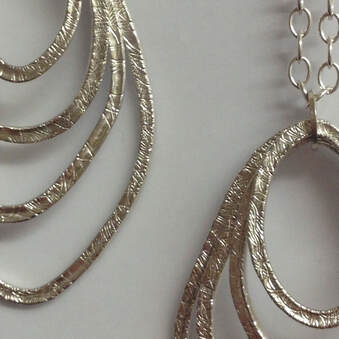 close up section of two sterling silver textured necklaces